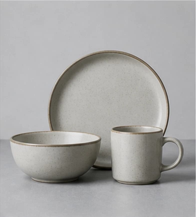 Matte stoneware dinner set on a cool gray studio surface
